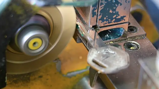 Mechanic Locksmith Cutting A Key On A Professional Key Machine by order.